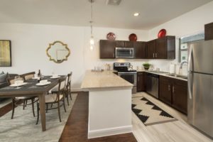 One Bedroom Townhome Kitchen with Dark Cabinets and Stainless Steel Refridgerator