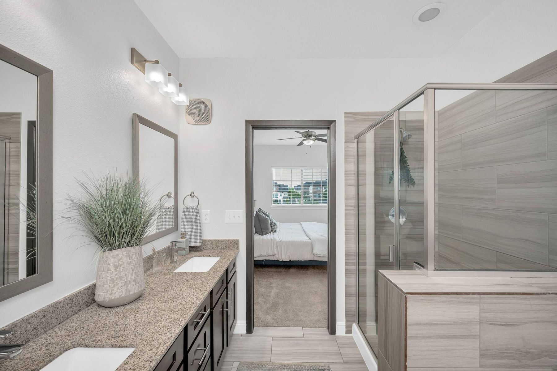Empty room with wood floors, ceiling fan, and sliding glass door leading to a patio with vertical blinds at Apex West Midown.